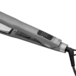Um close-up da chapinha Prancha Original Extreme 260 °C/500 °F na cor cinza, com display LED de temperatura e botões de controle, mostrada conectada à tomada com um cabo de alimentação preto preso à base.