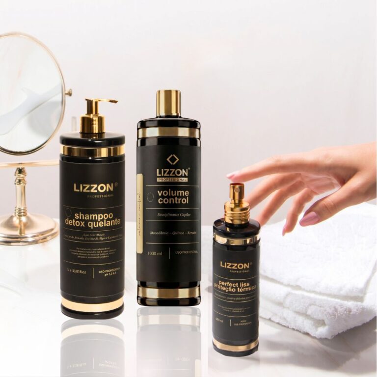 Três produtos de tratamento capilar Kit Liso Blindado estão dispostos em uma superfície branca ao lado de toalhas brancas dobradas, com uma mão alcançando um frasco e um espelho de mesa redondo visível ao fundo.