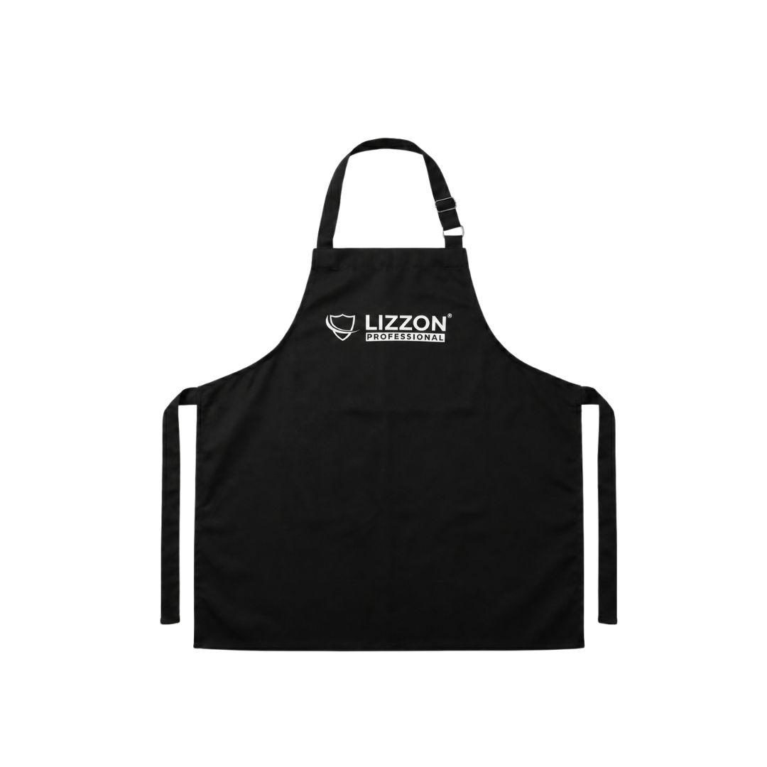Avental Lizzon Professional na cor preta com alça ajustável no pescoço, dois laços na cintura e o logotipo LIZZON PROFESSIONAL com um ícone de escudo no peito.
