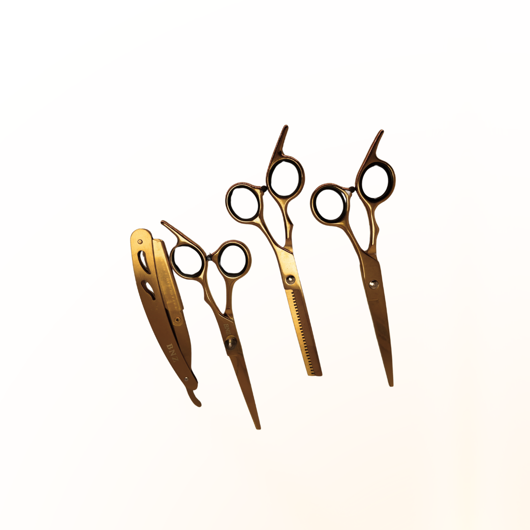 O Jogo de Tesouras Lizzon, um conjunto de cabeleireiro dourado que inclui um prendedor de cabelo, uma tesoura comum, uma tesoura de desbaste e uma tesoura reta, está organizado ordenadamente em uma fileira em um fundo branco liso.