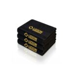 Quatro toalhas pretas Toalha Lizzon cuidadosamente empilhadas, cada uma com o logotipo amarelo da LIZZON e o bordado "MICROFIBER TOWEL", são exibidas em um fundo branco, oferecendo estilo e funcionalidade premium.
