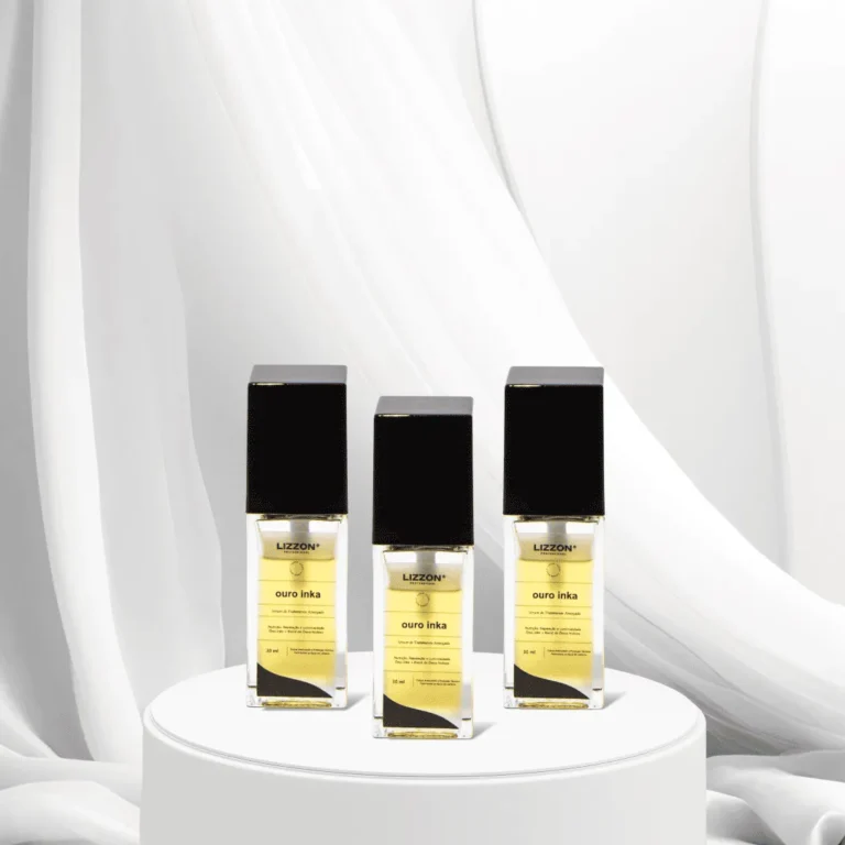 Três frascos do perfume Lizzon Ouro Inka com tampas pretas e rótulos dourados são exibidos em um pedestal redondo branco, em um fundo de tecido branco macio, mostrando a elegância do estilo característico de Lizzon.