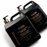 Dois frascos pretos de 2,5 litros do Kit Lavatório Inteligente Coiffeur (Smart Balm 5 em 1 + Smart Shampoo), com bombas douradas e rótulos bilíngues em italiano e inglês, são mostrados em um fundo branco - perfeitos para qualquer lavatório inteligente.