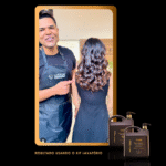 Um cabeleireiro com avental preto está ao lado de uma mulher com cabelos castanhos longos e brilhantes perto do kit Lavatório Inteligente Smart Balm 5 em 1 + Smart Shampoo, com dois frascos de produtos pretos vistos no canto inferior direito. Ambos estão de costas para a câmera.