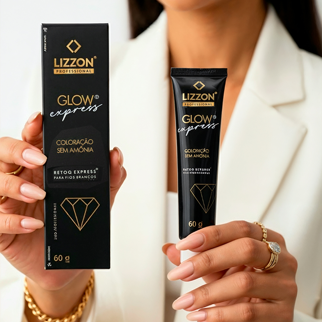 Uma pessoa vestindo um blazer branco segura uma caixa preta e um tubo de kit de coloração de cabelo Retoq Express (Glow Express), ambos com texto dourado e um gráfico de diamante. A pessoa tem unhas bem cuidadas e usa vários anéis.