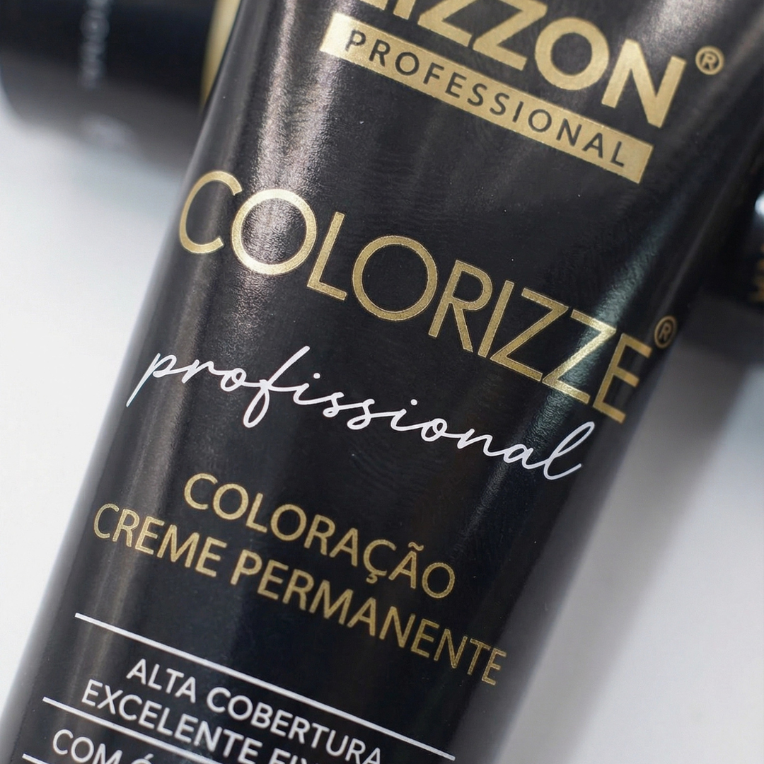 Um close-up de um tubo com o rótulo Colorizze Coloração Creme Permanente em texto dourado e branco sobre preto, indicando que se trata de um creme de coloração permanente para cabelos.