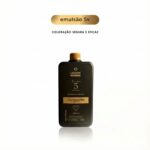 Um frasco preto com o rótulo Emulsão Oxidante Express 05 Vol 900ml está centralizado em um fundo branco liso. Acima do frasco, o texto diz emulsão 5v e Coloração segura e eficaz em português.