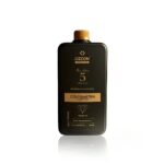 Um frasco retangular preto com uma tampa dourada com o rótulo Emulsão Oxidante Express 05Vol. 900ml apresenta detalhes dourados para resultados rápidos e profissionais.