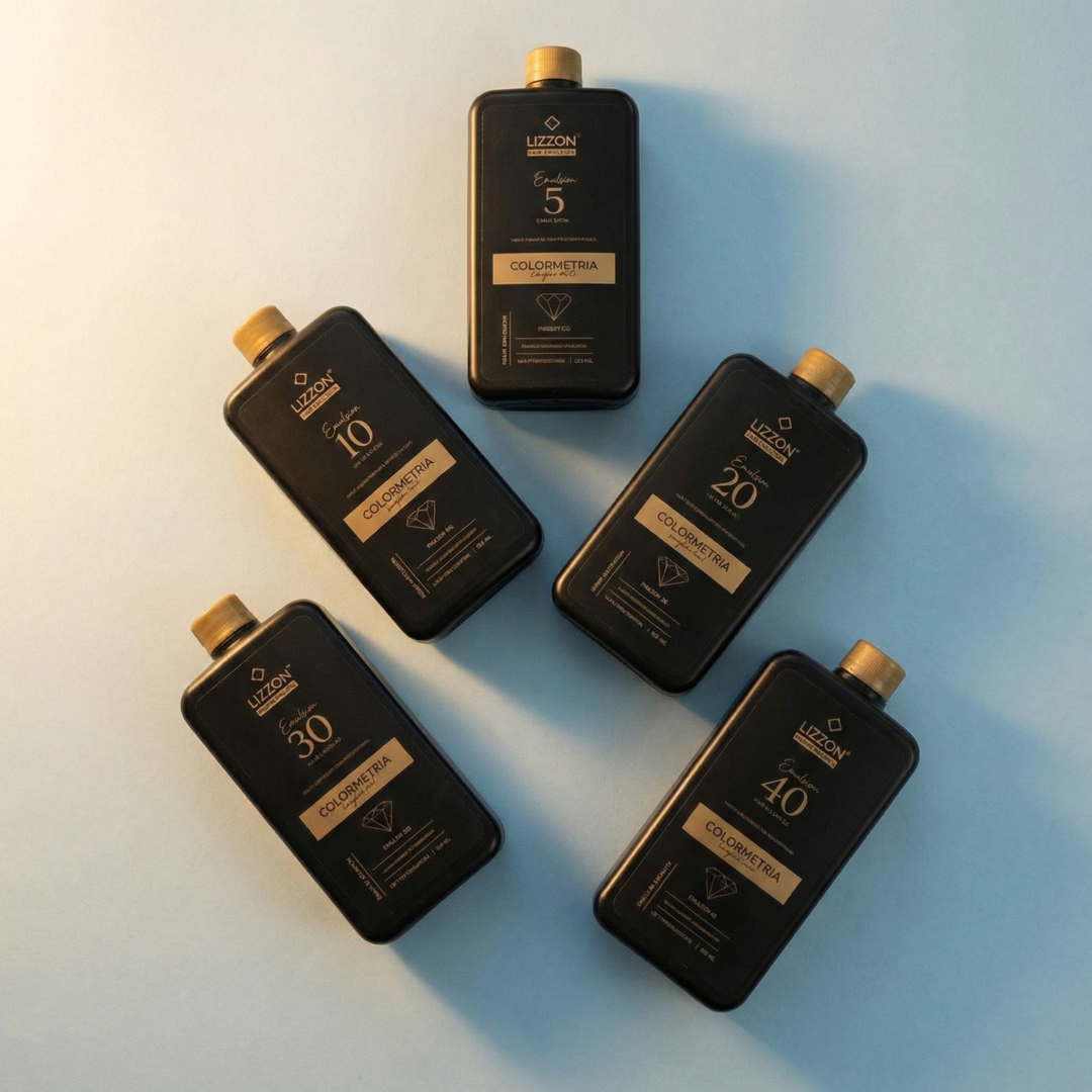 Cinco frascos pretos com tampas douradas, com os rótulos 5, 10, 20, 30 e 40, estão espalhados em um fundo azul claro. Cada um apresenta o rótulo Kit Emulsão Oxidante Colorimetria Express (5 unidades) em dourado e branco.