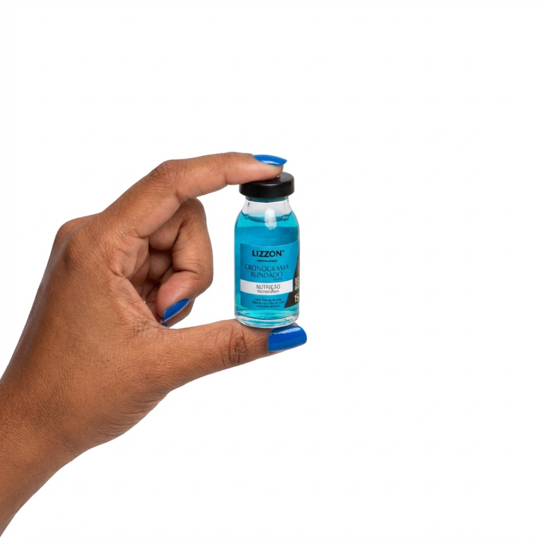 Uma mão com unhas pintadas de azul segura um pequeno frasco de líquido azul rotulado como Kit Power Dose em um fundo branco liso - ideal para a rotina do Kit Cronograma Blindado.