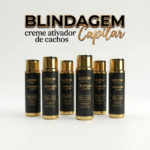 Seis frascos de Creme Ativador de Cachos Leave In Blindagem Capilar 300 ml estão dispostos em uma fileira sobre um fundo branco, com embalagem preta e dourada e detalhes do produto exibidos acima.