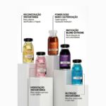 Cinco frascos de tratamentos capilares Kit Power Dose em cores diferentes são exibidos em pedestais brancos, cada um rotulado para reconstrução instantânea, hidratação, nutrição, nano cauterização ou tonalização do loiro.
