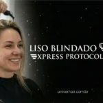 Uma mulher de cabelos loiros sorri enquanto tem seus cabelos secados em um salão de beleza. O texto "Liso Blindado Express Protocolos" aparece em um fundo preto com ilustrações de ferramentas de modelagem de cabelo.