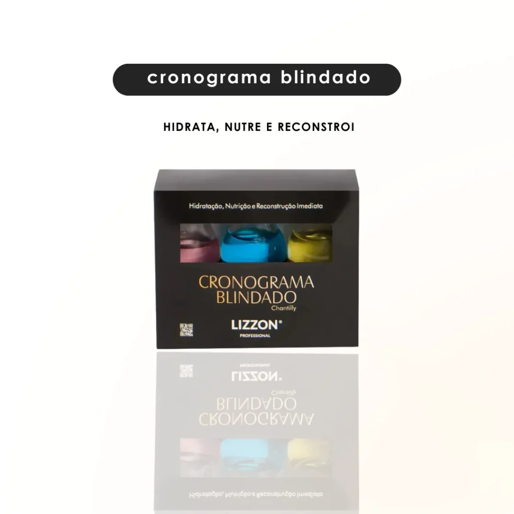 Uma caixa preta com o rótulo Cronograma Blindado Lizzon e três frascos visíveis em seu interior nas cores rosa, amarelo e azul. Acima, uma etiqueta diz cronograma blindado e, abaixo, diz hidrata, nutre e reconstrói.