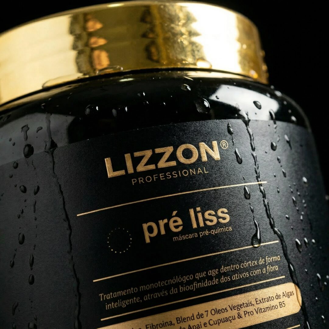 Um close-up de um recipiente preto e dourado com o rótulo Lizzon Professional pré liss máscara pré-química, com gotas de água na superfície. O rótulo inclui detalhes do produto em português.
