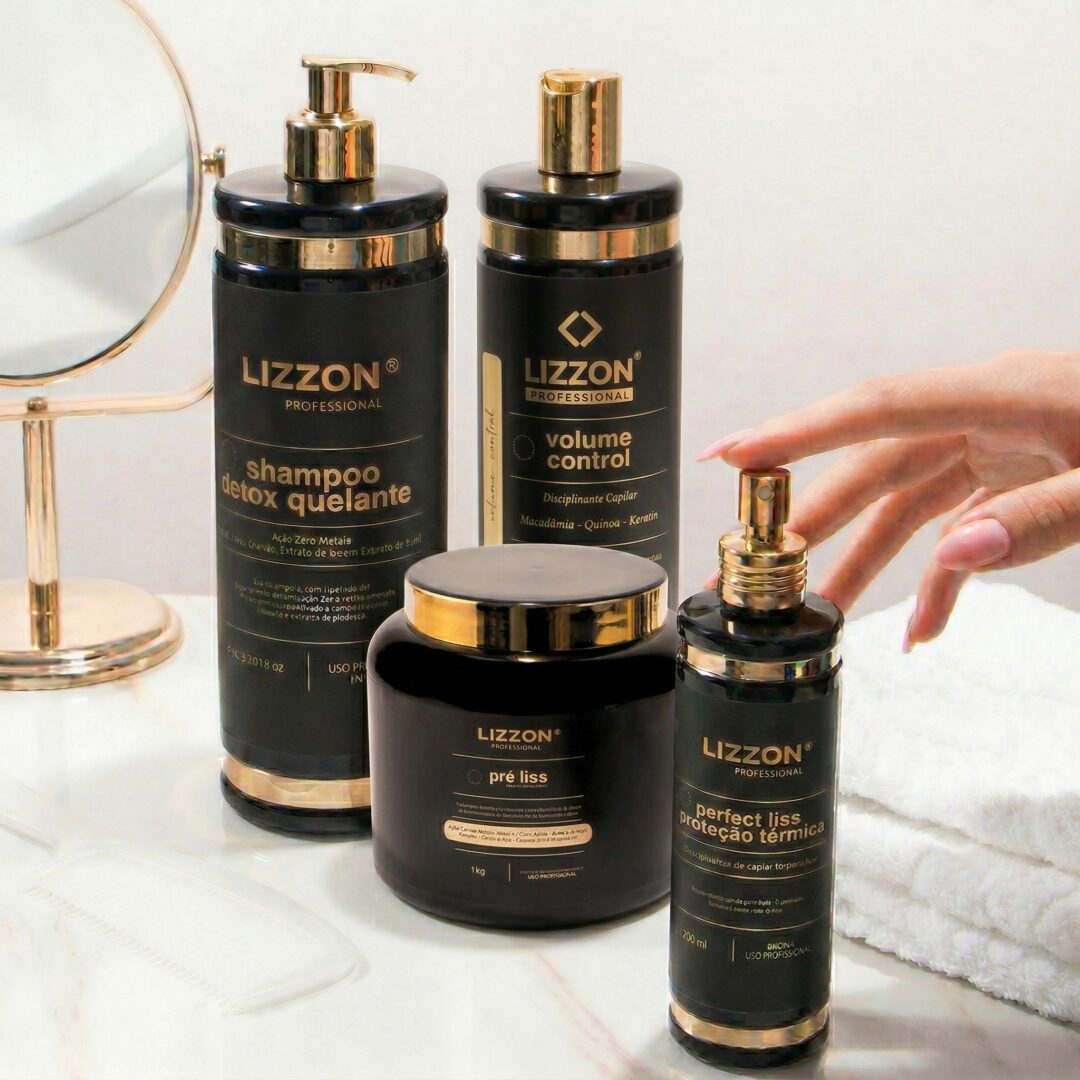 Quatro frascos pretos e dourados do Kit Liso Blindado (cópia) estão dispostos em uma superfície branca perto de um espelho redondo. Uma mão está prestes a borrifar um dos produtos: xampu, controle de volume, máscara capilar ou spray térmico.