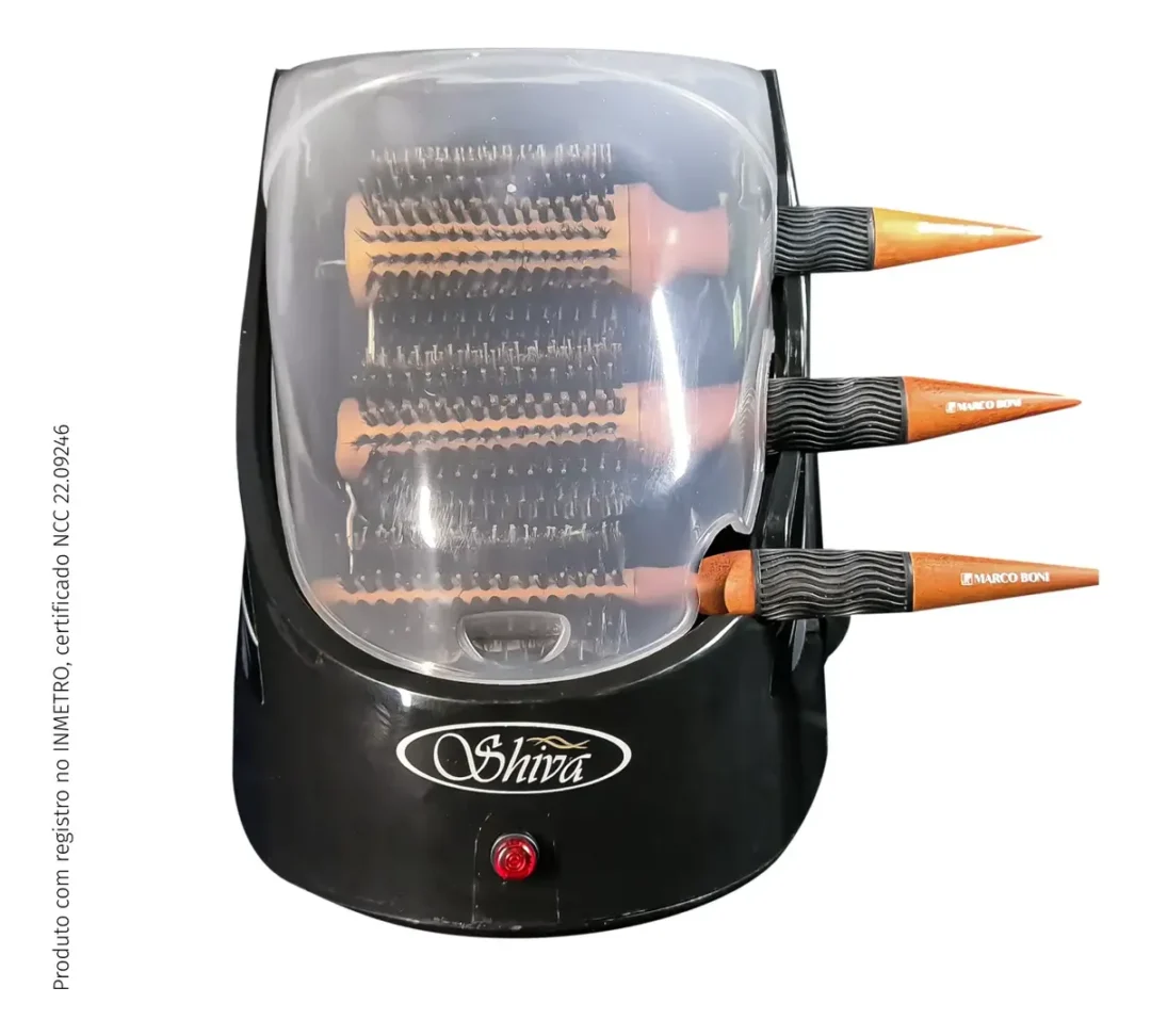 Um esterilizador elétrico de escovas de cabelo Shiva Care Preto 220 V, na cor preta, com três escovas redondas no interior e uma tampa transparente; um botão de ligar vermelho é visível na parte frontal, com três cabos de escova saindo do lado direito.