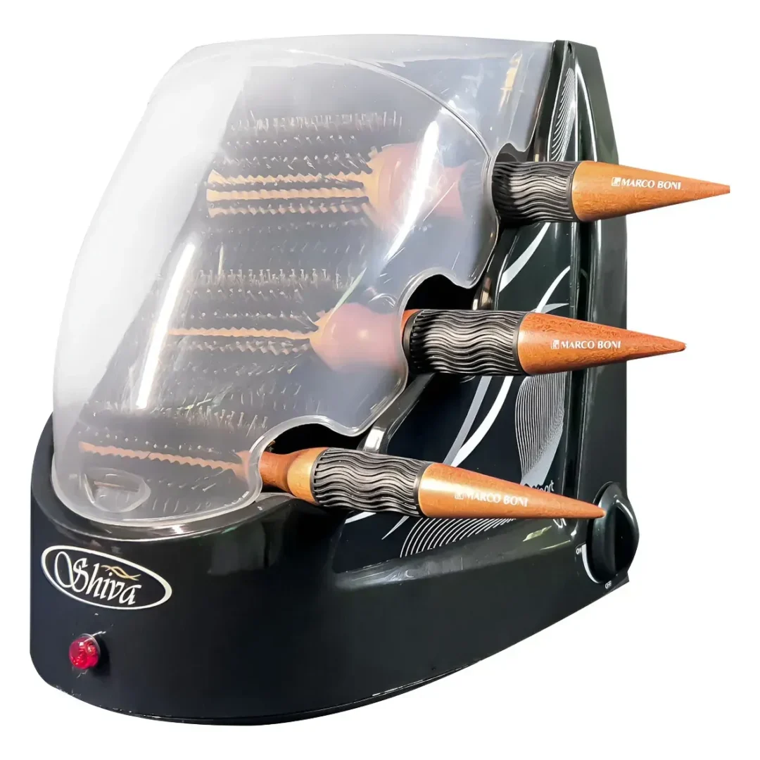 O Higienizador de Escovas Shiva Care Preto 220 V é um esterilizador de escovas de cabelo nas cores preto e prata, com capacidade para três escovas redondas da Marco Boni com cabos de madeira e cerdas pretas. Possui uma tampa transparente e um botão liga/desliga na parte frontal.