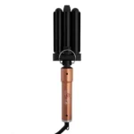 O MODELADOR BEACH WAVE TRIONDAS BILVOLT é um aparelho elétrico para modelar cabelos nas cores cobre e preto, com uma alça cilíndrica e quatro cilindros grandes de cerâmica preta dispostos em forma de trevo, quando vistos de frente. Um cabo de alimentação sai da base da alça.